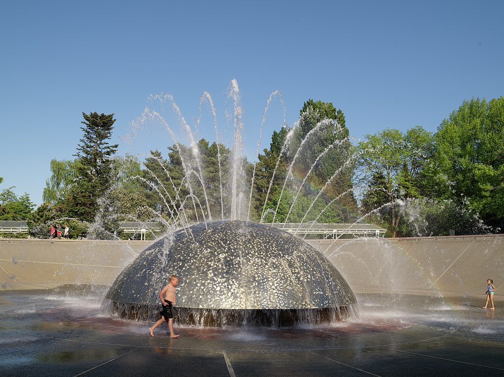 Children splashing in the interactive fountain at Riverside Commons
